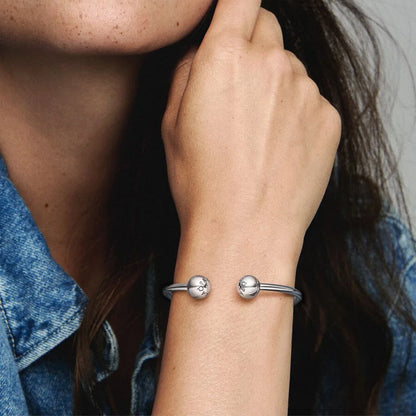 Silver open bangle with silicone stoppers and interchangeable end caps